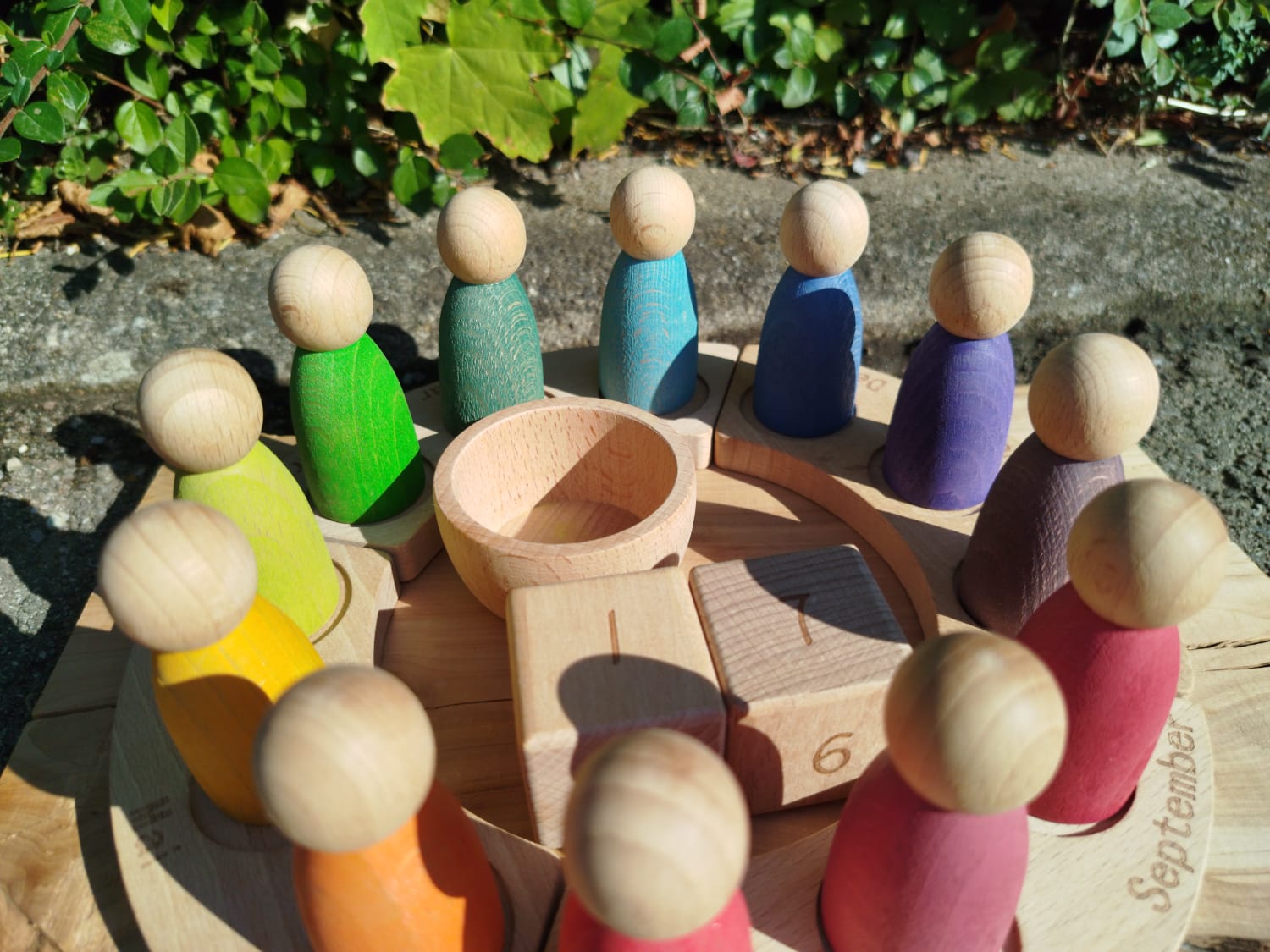 Jahreskalender aus Holz mit bunten Figuren